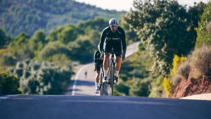 Cyclist training on a rural uphill road, capturing the essence of outdoor sports and countryside scenery.